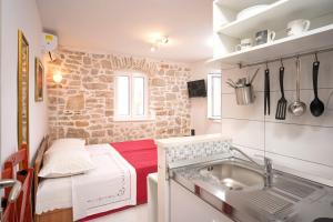 Una cocina con fregadero y una cama en una habitación. en Apartments Lotti 2, en Stari Grad