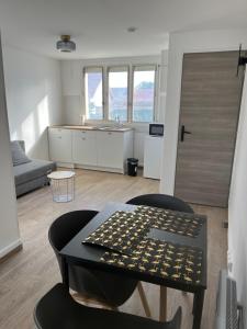 a kitchen and living room with a table and chairs at Appartements proches CDG Le Bourget dans maison francilienne typique in Le Blanc-Mesnil