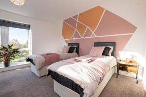 a bedroom with two beds and a large window at Central, Large 4 double bedroom house in Leicester