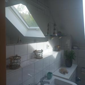 een witte badkamer met een wastafel en een raam bij KiKo in Amoltern