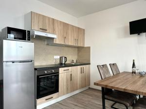 uma cozinha com um frigorífico e uma mesa com cadeiras em Sky Apartments 512 em Plzeň