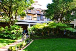a garden in front of a building at Protea Hotel by Marriott Johannesburg Balalaika Sandton in Johannesburg