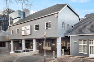 a gray building with a street light in front of it at Protea Hotel by Marriott Johannesburg Balalaika Sandton in Johannesburg