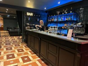 a woman standing at a bar in a restaurant at HOTEL & SPA GASQUET in Luchon