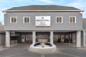 a building with a fountain in front of it at Protea Hotel by Marriott Johannesburg Balalaika Sandton in Johannesburg