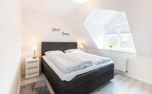 a bedroom with a large bed in a white room at Hafen im Blick in Kappeln