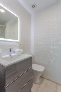 a white bathroom with a sink and a toilet at Céntrico apartamento Templo Quevedo Gran parking gratis in Granada