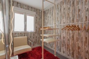 a room with a chair and shelves on a wall at Center Templo Garden parking gratis in Granada