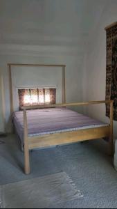 een slaapkamer met een houten bed in een kamer bij Flaneurstudio in Szentendre