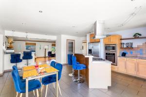 a kitchen with a table and blue chairs in it at Luxury Executive Home in Redlands