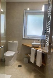 La salle de bains est pourvue de toilettes, d'un lavabo et d'une fenêtre. dans l'établissement Ar da Beira - Serra da Estrela, à Belmonte