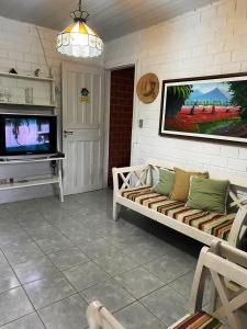 sala de estar con sofá y TV de pantalla plana en Casa Tina, en Jaguaribe