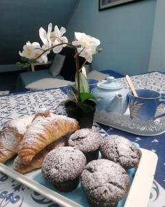 un piatto di muffin e pasticcini su un tavolo di B&B- La Casa Blu- Forum di Assago, Humanitas, Milanofiori, IEO a Rozzano