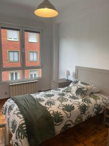 una camera con un letto e due finestre di Apartamento Buenavista en Oviedo a Oviedo
