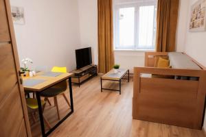 ein kleines Apartment mit einem Bett, einem Schreibtisch und einem Tisch in der Unterkunft Apartmán 4, K Lanovce in Jáchymov