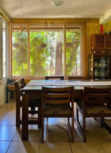 - une salle à manger avec une table, des chaises et des fenêtres dans l'établissement El encanto tropical, a minutos del IRTRA, à Ajaxá