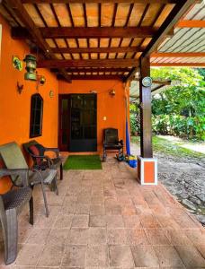 Cette maison orange dispose d'une terrasse avec des chaises et une horloge. dans l'établissement El encanto tropical, a minutos del IRTRA, à Ajaxá