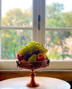 eine Schale mit Obst auf einem Tisch vor einem Fenster in der Unterkunft Pope's Suites in Rom