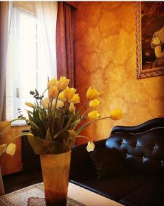 un jarrón con flores amarillas en la sala de estar en Pope's Suites, en Roma