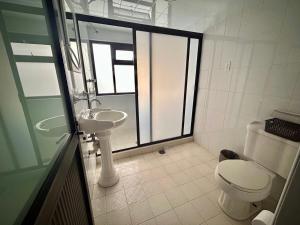 La salle de bains blanche est pourvue de toilettes et d'un lavabo. dans l'établissement Hotel MH, à Chignahuapan