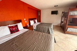 Cette chambre comprend 2 lits et une télévision. dans l'établissement Hotel MH, à Chignahuapan