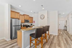 a kitchen with a counter with chairs and a refrigerator at 8960 Cat Palm Road in Kissimmee