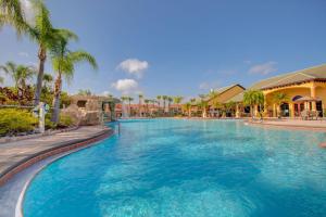 uma grande piscina num resort com palmeiras em 8960 Cat Palm Road em Kissimmee