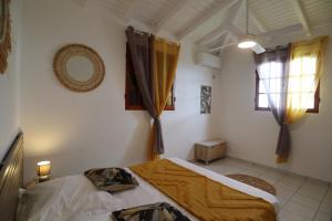 1 dormitorio con 2 camas y ventana en Ti-Coco Lodge - Calme Spacieux Vue Nature Proche Commerces Plages, en Sainte-Anne