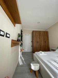 een slaapkamer met een bed en een kruk erin bij Stone City Apartament in Gjirokastër