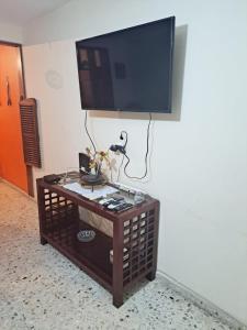 a flat screen tv on a wall with a coffee table at Malecón Casa Grande Económica Gran Ubicación in Mazatlán