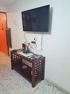 TV de pantalla plana en la pared con mesa de centro en Malecón Casa Grande Económica Gran Ubicación, en Mazatlán