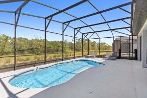 uma piscina interior num edifício com tecto de vidro em 6103 High Seas Drive em Orlando
