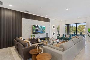 uma sala de estar com sofás e uma televisão na parede em 6103 High Seas Drive em Orlando