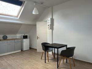 uma cozinha com mesa e cadeiras num quarto em Appartements proches CDG Le Bourget dans maison francilienne typique em Le Blanc-Mesnil