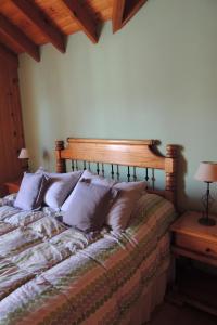 Un dormitorio con una cama con almohadas. en Allegra, casa de descanso en San Martín de los Andes