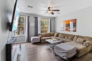 uma sala de estar com um sofá e uma televisão de ecrã plano em 5063 Tideview Circle 66 em Orlando