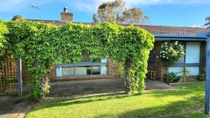 a house with an ivy covered fence at Redwood Beach House - with 10 percent off until September in Cowes