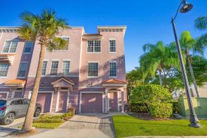 ein rosafarbenes Haus mit Palmen und einem Straßenlicht in der Unterkunft 8000 Cool Breeze Drive 108 in Orlando