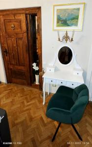 a room with a white desk and a green chair at Charm Old Town Studio in Braşov