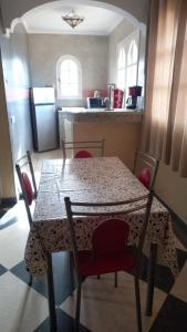 a kitchen with a table and chairs and a kitchen with a refrigerator at Riad Al Afrah in Id Chahadene