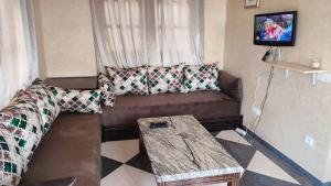 a living room with a couch and a table at Riad Al Afrah in Id Chahadene