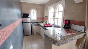 a small kitchen with a counter and a refrigerator at Riad Al Afrah in Id Chahadene