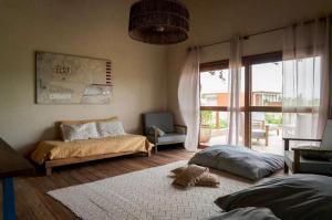 a bedroom with two beds and a large window at Magaral Casa de Praia in Pôrto de Pedras