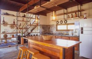 a kitchen with a large wooden counter and a refrigerator at Magaral Casa de Praia in Pôrto de Pedras