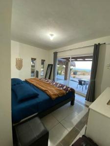 - une chambre avec un lit bleu et un balcon dans l'établissement Casa De Descanso KAYKA, à La Ventana