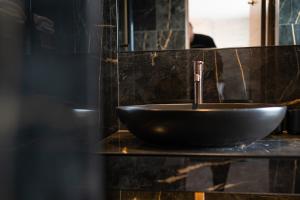 a bathroom with a black sink and a mirror at The Hyde - At Dunning's Bar in Watford +31 photos