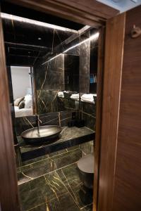 a bathroom with a sink and a mirror and a bed at The Hyde - At Dunning's Bar in Watford