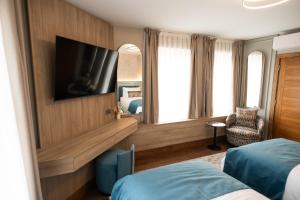 a hotel room with a bed and a tv at The Hyde - At Dunning's Bar in Watford