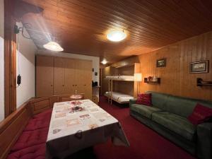 een woonkamer met een tafel en een groene bank bij Soldanella Cervinia apartment Vda Vacanze in Vetta CIR 0253 in Breuil-Cervinia
