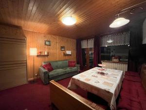 een woonkamer met een tafel en een bank bij Soldanella Cervinia apartment Vda Vacanze in Vetta CIR 0253 in Breuil-Cervinia